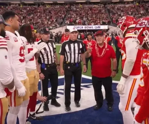 coach bobby watson wears a double portion supply cap during the super bowl 58 coin toss